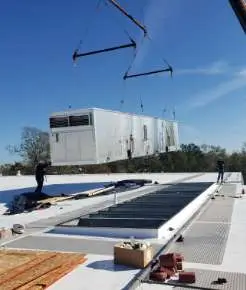 A roof mounted HVAC unit being installed.